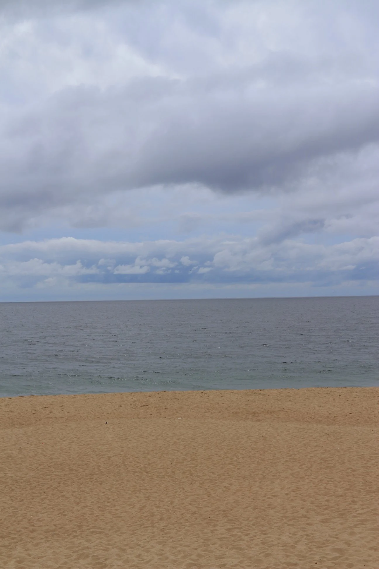 Interessante contraste entre a areia, o mar e a tempestade que se aproxima